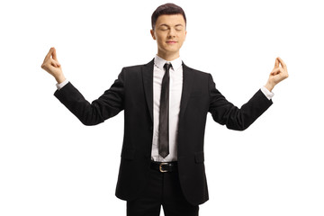 Young guy in a suit and tie practicing meditation with closed eyes