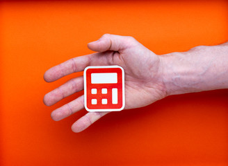 Il faut tout calculer, pictogramme imprimé de calculatrice tenu par un main d'homme, sur fond orange