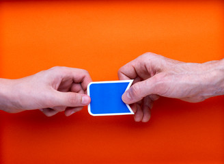 Deux mains en opposition tiennent une étiquette bleu imprimée pour marquage, sur fond orange