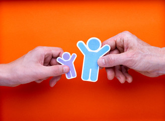 Illustration famille monoparentale, deux mains tenant chacune une illustration d'homme ou de femme et d'enfant avec les bras levés, contents de se retrouver, réconciliation, sur fond orange