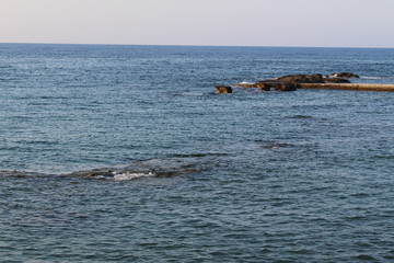 Mediterranean sea waves splashing at the rocks with foam in Chania, Crete Island, Greece.