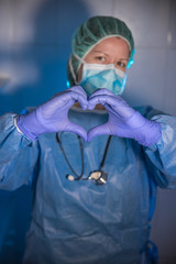 Doctora haciendo el símbolo de corazón con sus manos, mostrando el cariño a los pacientes, y...