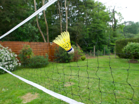 Yellow Badminton Shuttlecock In A Net, Green Garden In The Background