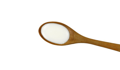 Milk or Sour cream isolated on white background. Yogurt in a wooden spoon isolated. 