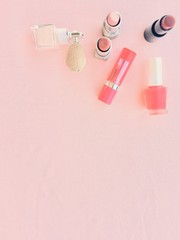 Fototapeta na wymiar Lots of make up items with pink background, lipsticks and nail polish