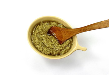 Pesto spread or blob isolated on white background. Green italian homemade spilled sauce made of ground basil, garlic, pine seeds, olives and pecorino. 
