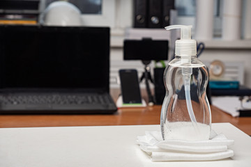 Antiseptics. Pocket antiseptics stand on the table. Concept - sanitizer for cleaning hands. Means for disinfecting. ?oncept - purchase of antiseptic agents. Disinfection bottles next to a laptop.
