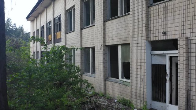 Abandoned building exterior with broken windows. Aerial view. Low angle shot
