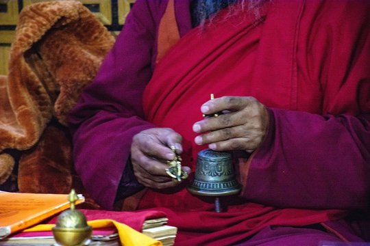 Midsection Of Monk Holding Traditional Bell