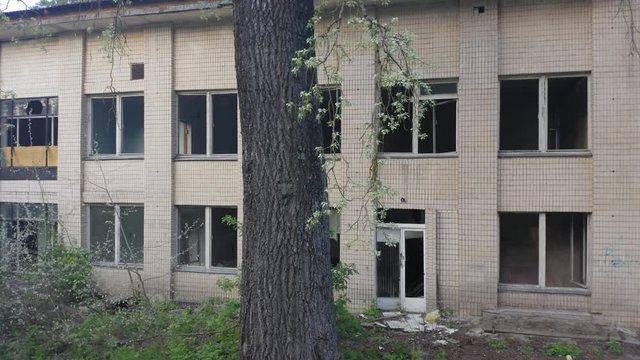 Abandoned building exterior with broken windows. Aerial crane elevator shot