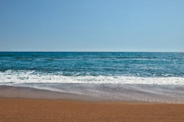 Waves on the beach. Sea with clean blue sky and sandy beach in Antalya, Turkey.