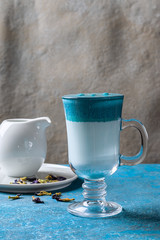 Dalgona Matcha Blue Latte, cream sweet drink in a cup on a blue background