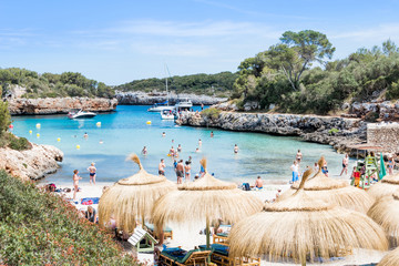 Landscape of sky, sea and people on the beach. Cala Sa Nau, Majorca