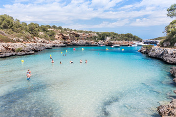 Landscape of sky, sea and people on the beach. Cala Sa Nau, Majorca