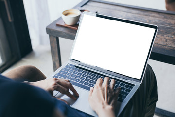 computer mockup image blank screen with white background for advertising,hand woman work using laptop contact business search information on desk at coffee shop.marketing and creative design