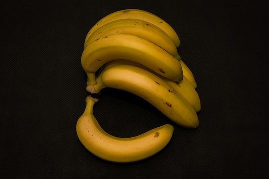 Isometric view of yellow bananas on black surface