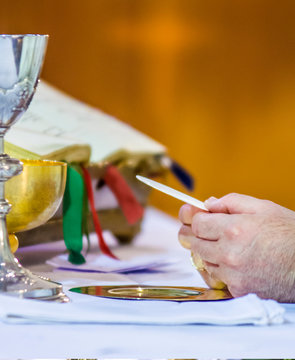 hands of Pope Francis with host and chalice with wine in the churches of the world