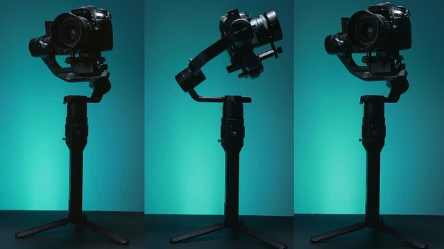 Estabilizador o Gimbal con una camara montada, haciendo movimientos de grabacion con fondo de color azul