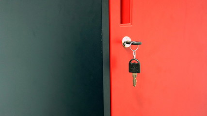 A safe in a closed state is red and the key hangs in the closet