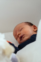 Newborn sleeping in his bed. A cute little boy. 