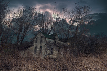 An abandoned house in rural Ontario with wind and ominous clouds circling above. 