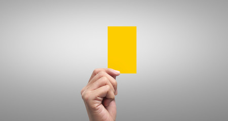 Referee hand holding yellow cards. isolated
