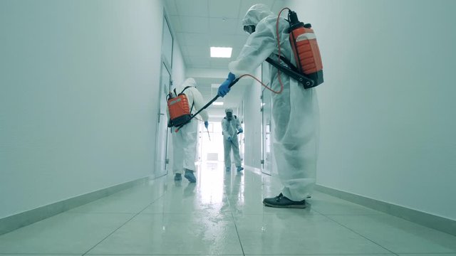 Cleaners disinfect a hallway in office building to kill coronavirus.