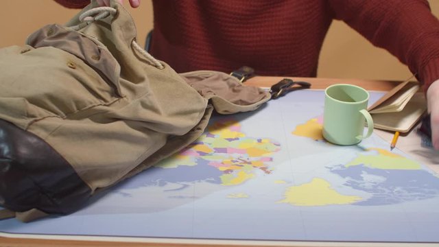 Man puts different things in a rag backpack