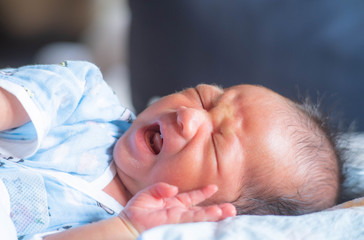 The Newborn Baby infant crying colic face and sleep on the bed 