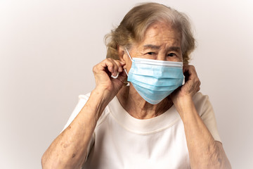 Close-up face of a old Asian woman wearing a mask