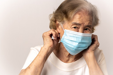 Close-up face of a old Asian woman wearing a mask