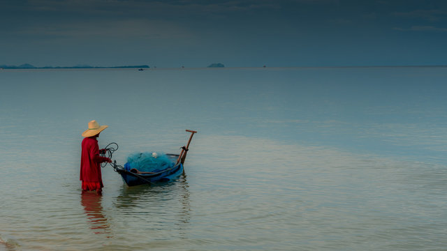 Older Man Holding Onto A Smal Boat In Calm Seas On The Gulf Of Thailand