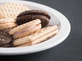 Assorted cream cookies and biscuits sitting on a plate