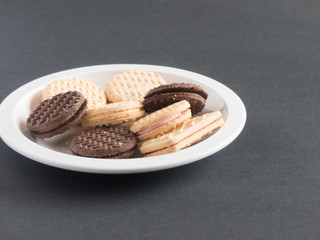 Assorted cream cookies and biscuits sitting on a plate