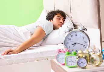 Young man having trouble waking up in early morning
