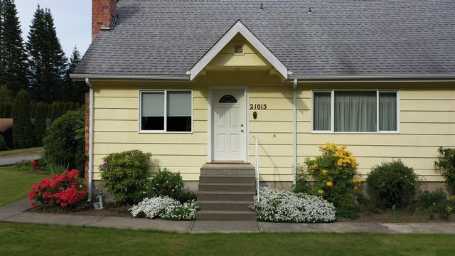 Departing from a small yellow American cottage style house; 4k dolly shot