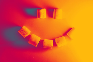 emoji from sweet yogurt. chewing marshmallow on a turquoise background