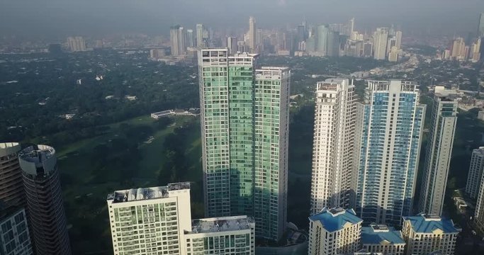 Aerial flight through high rise buildings revealing metropolitan city skyline. Drone, 4K.
