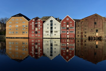 background of colourful storehouse and reflection near Nidelva river T rondheim Norway