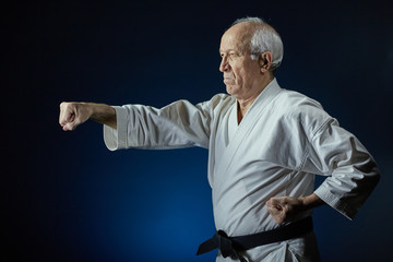 On a blue background, an old man athlete beats a punch arm © andreyfire