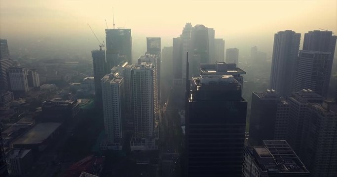 Aerial flight towards high rise buildings towards metropolitan city skyline. Drone, 4K.