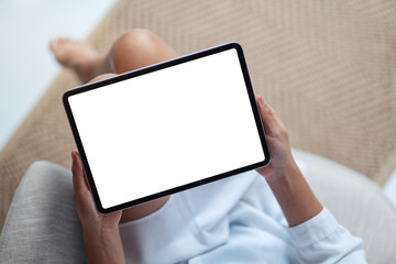 Top view mockup image of a woman holding black tablet pc with blank white desktop screen