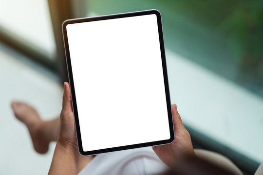 Top view mockup image of a woman holding black tablet pc with blank white desktop screen