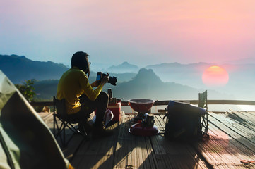 Fototapeta premium Woman traveler camping take a photo in Mountains with Beautiful summer.