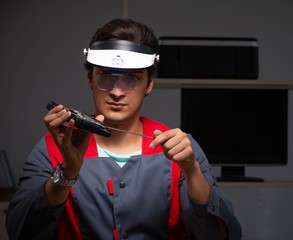 Young handsome repairman repairing computer