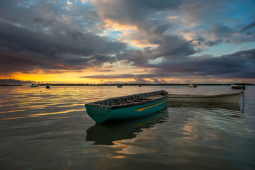 fabulous view of the sunset in Mauritius. Fishing boats on the background of mountains and colorful...