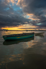 fabulous view of the sunset in Mauritius. Fishing boats on the background of mountains and colorful clouds