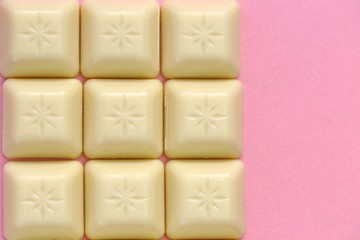 White chocolate bar close-up on a pink background.