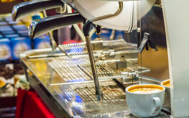 Espresso Machine pouring fresh coffee into cups at Local Coffee Shop.

