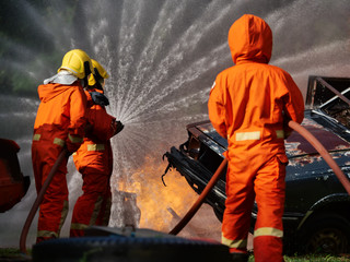 Fototapeta na wymiar firefighter spray water to fire burning car workshop fire training